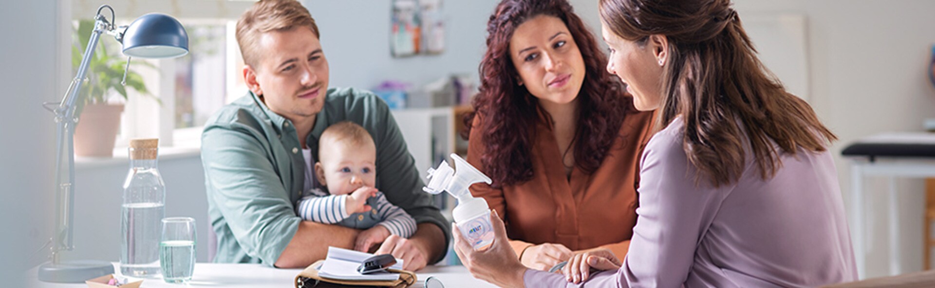 A family looking at a woman all sitting around a table